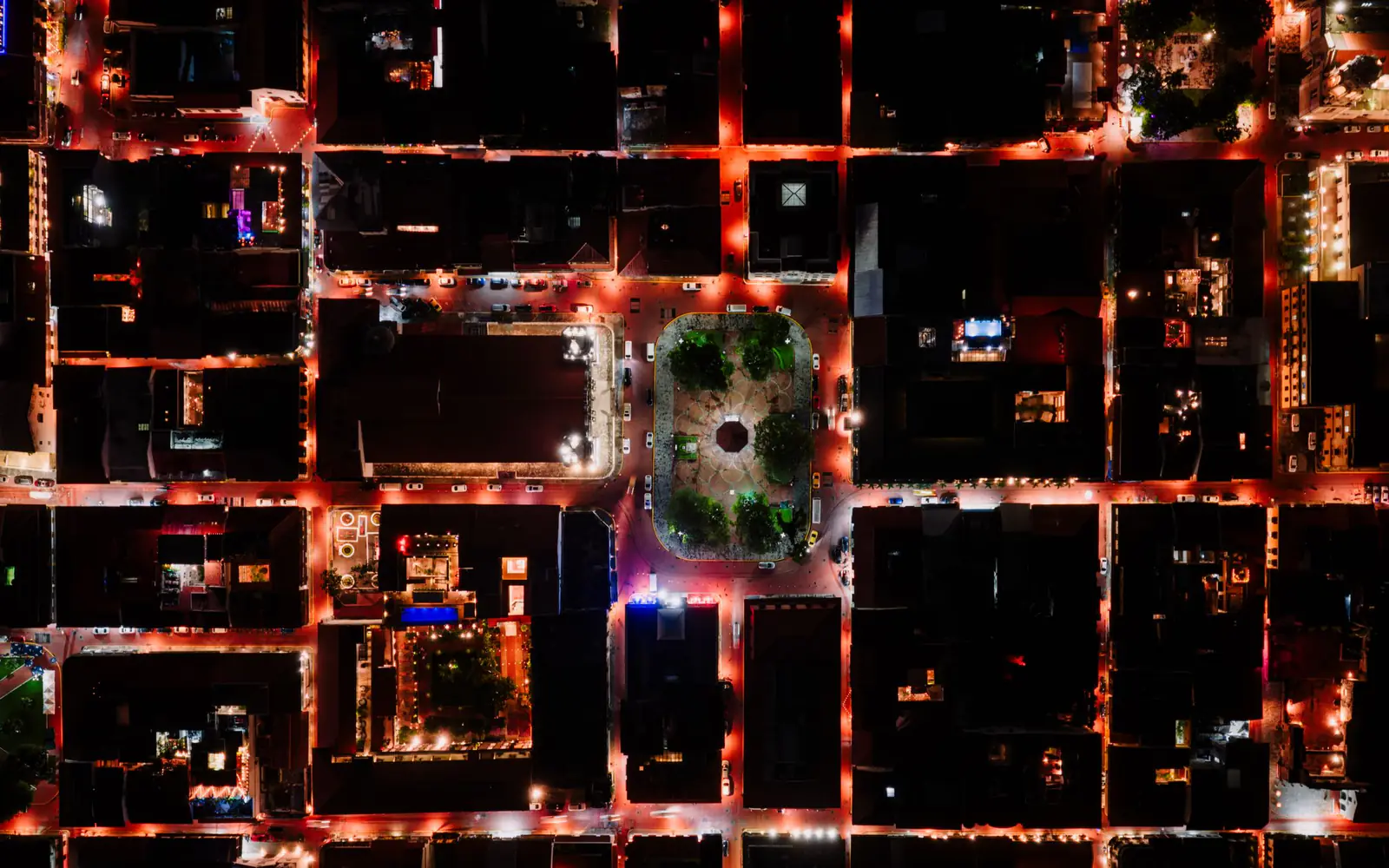 An aerial view of a city street grid lit at night