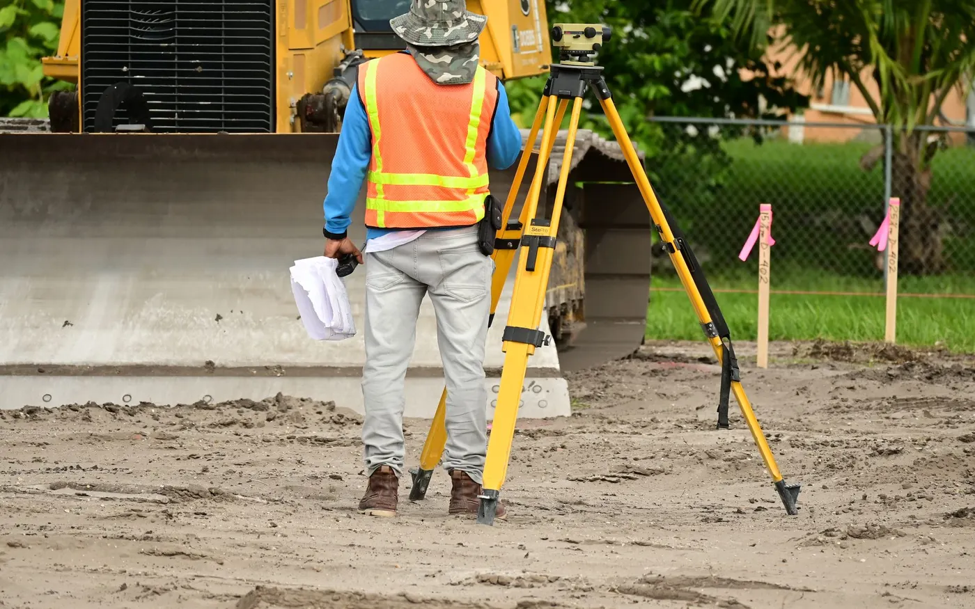 A surveyor taking measurements with an instrument on site