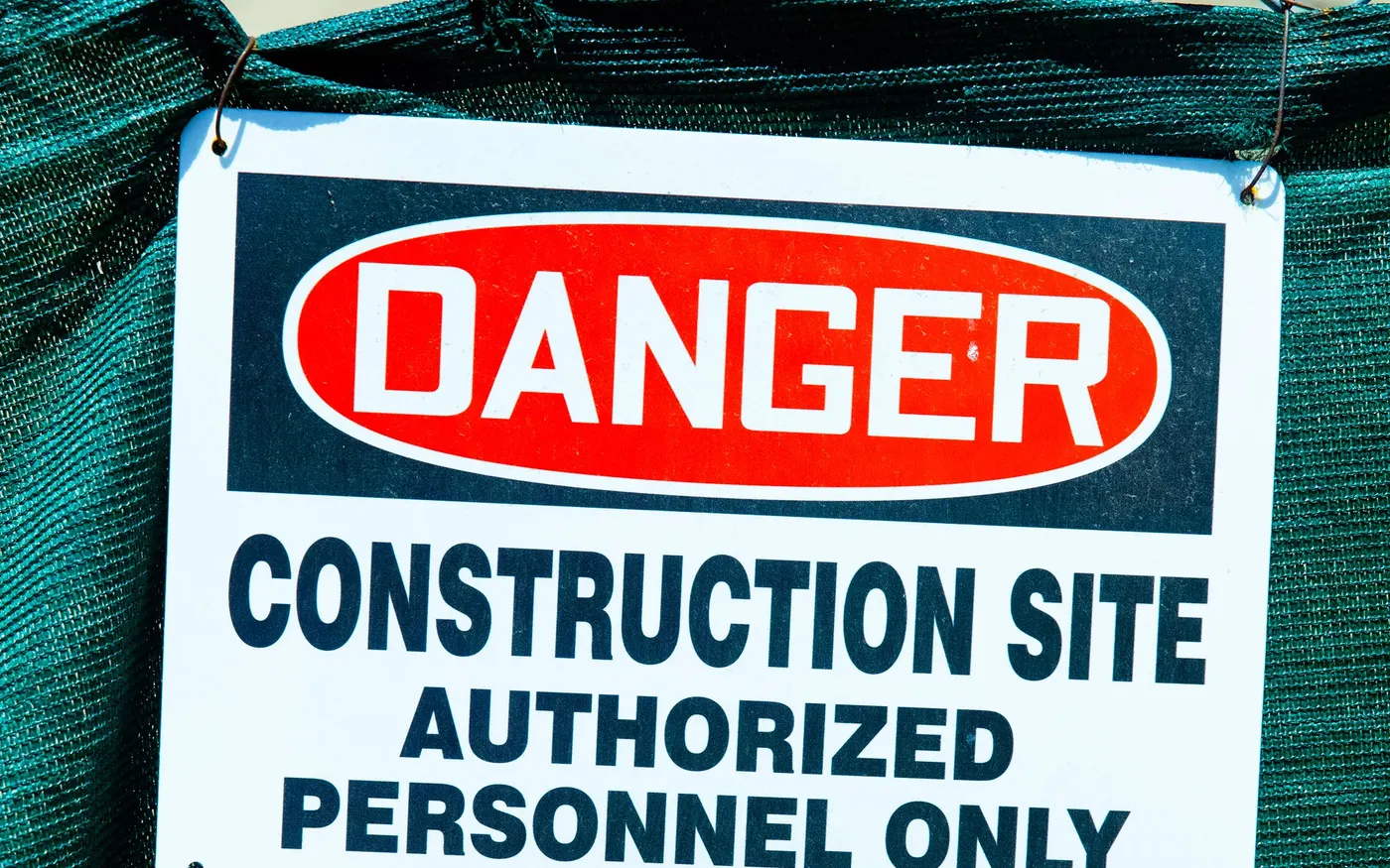 A danger sign fixed to a wire fence