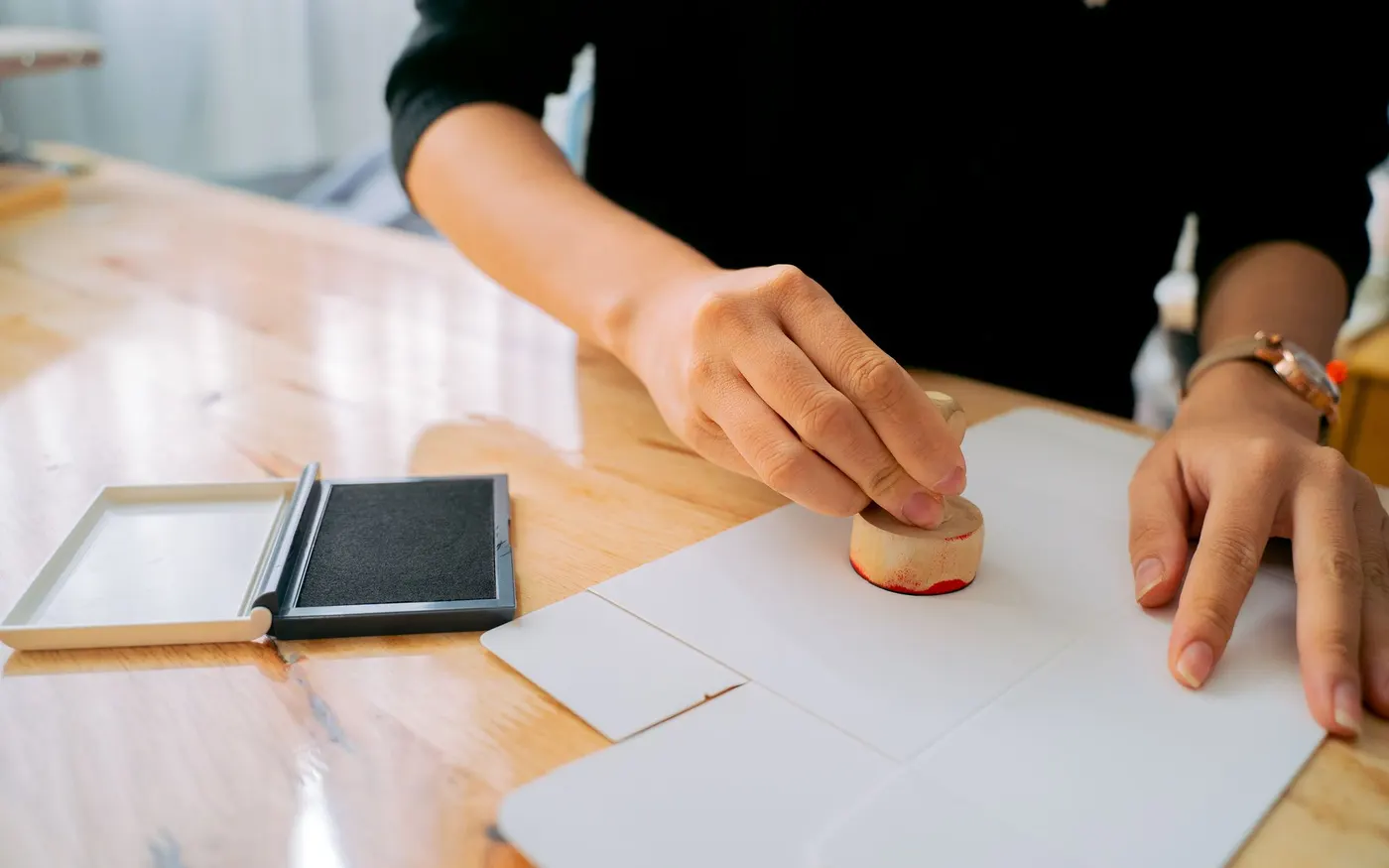 A stamp being applied to a document on a desk